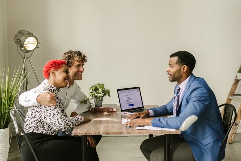 Advisor meeting a couple at a desk with a laptop
